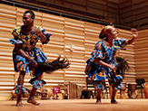 Photo of two dancers from Saakumu performing on stage.