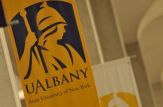 A yellow banner with the University of Albany logo in purple