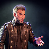 Close-up shot of Joshua Kane performing on stage. 