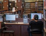 A student sits at a computer in Dewey Library on the Downtown Campus