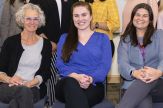 three women sit together in a class photo