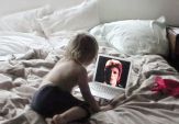 A boy watches a video of David Bowie on a laptop on a rumpled bed in this image by Frances Stark called “This Is Not Exactly a Cat Video”