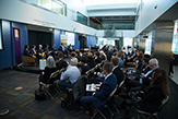 Sideview from back left of audience viewing panelists in the Massry Center for Business.