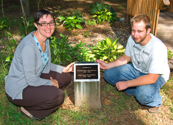 Hillel Executive Director Rabbi Nomi Manon and Hillel staffer David Hausler with the commemorative plaque bearing Susan Sherman's name.