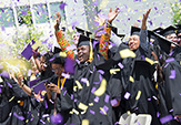 UAlbany students celebrate commencement with purple and gold confetti.