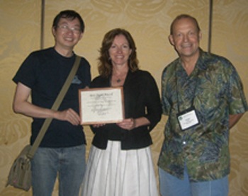 From left, Lei Zheng and Theresa Pardo accept the award from Jochen Scholl. 