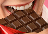 Woman eating a chocolate bar.