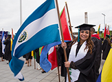 A student carries the El Salvador flag during UAlbany's 2016 undergraduate commencement ceremony.