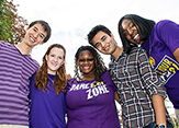 A diverse group of UAlbany students take a photo on campus.