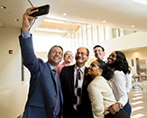 Incoming President Havidán Rodríguez takes a selfie with faculty and staff.