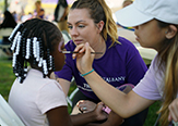 UAlbany L-LC students lead face paint activity during weekend of volunteer service.