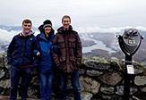 Sara Lance stands atop the Whiteface Mountain Observatory with her graduate student and postdoc researcher.