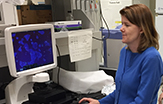 Melinda Larsen, associate professor of biological sciences, examining salivary gland cells.