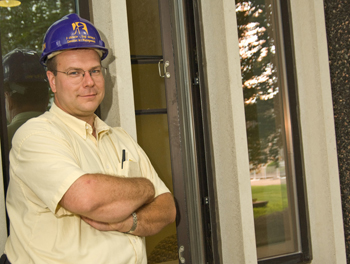 Construction Manager Bob Morawski standing in front of new windows.