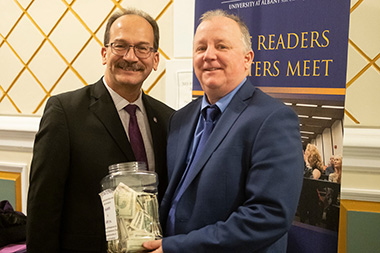 President Rodríguez (left) and New York State Writers Institute Director Paul Grondahl ’84 hold a donation jar that was passed up and down the rows of Page Hall during Monday night’s Hurricane Maria panel discussion. 