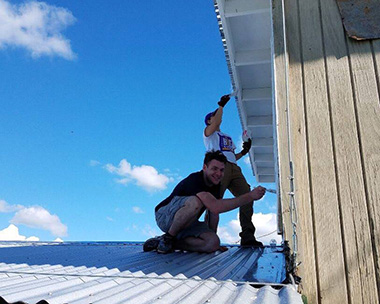 Photo of UAlbany student Stone Williams painting a home in Puerto Rico.