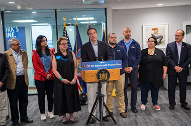 President Rodríguez (far right) stands with Gov. Cuomo during his announcement of the NY Stands with Puerto Rico Recovery and Rebuilding Initiative. 