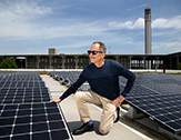 ASRC Senior Research Associate Richard Perez observes an array of 90 LG 350-watt solar panels installed on the Campus Center West addition roof.