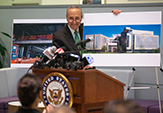 Sen. Schumer holds up renderings of UAlbany's ETEC building during his visit to campus on Monday, Oct. 6.