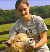 UAlbany student Erin LaBarge holding one of the ewes she studies at Longfield Farm.