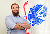 Chad Simpson next to the U.S. Army flag that hangs in the veterans' lounge.