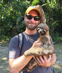 Stephen Coulthart holds a sloth in the Peruvian Amazon.