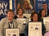 Advancement team members hold their framed winners' certificates