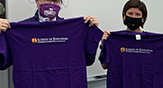 two students hold UAlbany School of Education T-shirts
