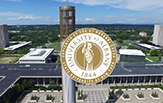 The University at Albany seal is imprinted over an aerial view of the uptown Podium