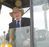 Coach Bob Ford commands the backhoe at groundbreaking of Bob Ford Field.