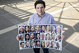 Austin Ostro holds up a large photo of 24 2020 Democrat Presidential candidates