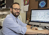 Paolo Forni sits before his computer in his Biology Building lab at UAlbany