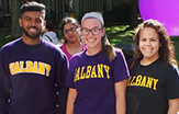 Three smiling University at Albany freshmen at the Main Fountain