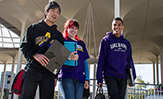 Smiling Ualbany students walk beneath the Podium arches