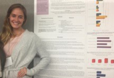 Tara Caemmerer in front of research poster.