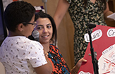 A UAlbany student works with a young boy on his restaurant menu sign
