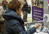 A woman at a glass display case looks over a tribute to Toni Morrison