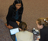 Vice President Nikki Gupta working with two local Girl Scouts.