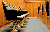 An empty jury box, showing telescreens for each juror