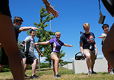 Incoming UAlbany freshman do a dance-exercise on the lawn by SEFCU Arena