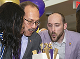 President Rodriguez, center, and a woman and man blow out the candles on the 175th anniversary cake
