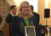 Carol Stenger holds a plaque in the rotunda of the Albany County Courthouse