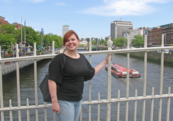 Kate Finkbeiner on a bridge with a scenic view in Ireland. 