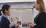 UAlbany Information Science Ph.D. Students Shannon Mersand and Xiaoyi Zhao in front of their research poster