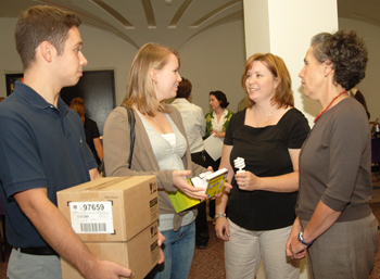 UAlbany sustainability director Mary Ellen Mallia hands out CFL light bulbs with students