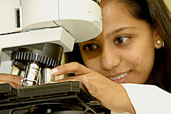 Girl looking at through a microscope