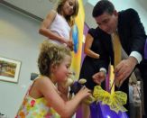 President George Philip Helps Hannah open her present from the UAlbany community