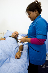 Registered nurse assisting patient lying in bed.