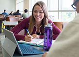 UAlbany students surround a laptop in the science library