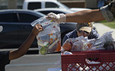 A U.S. marine hands a child a bagged lunch at Camp Pendleton in California.